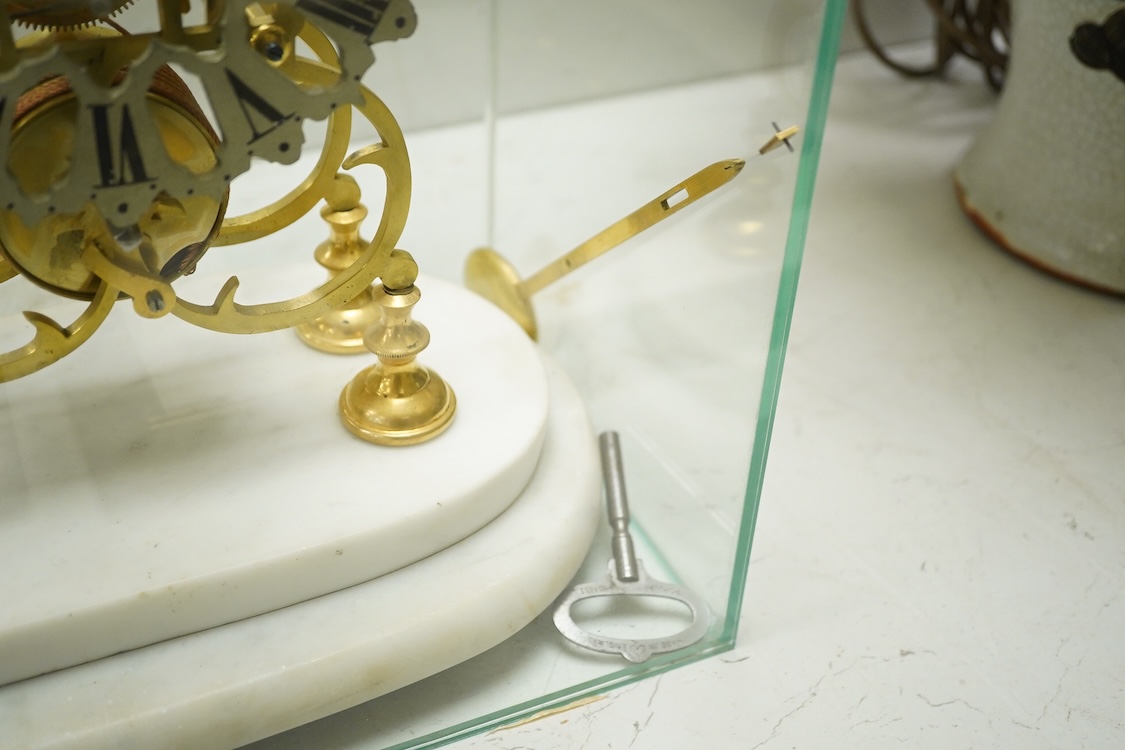A brass framed skeleton clock, with white marble stand, in glass case, case 39.5cm high